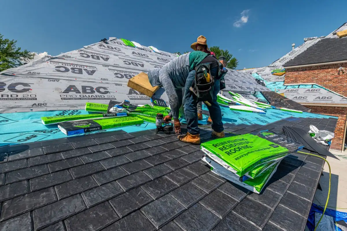 Roofer inspecting decking and underlayment on a residential roof in Springfield, MA